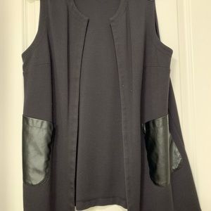 Black vest, large size, with leather-like details on the front pockets.